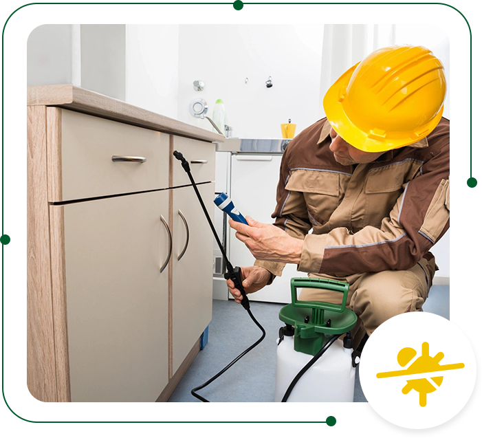 A man in yellow hard hat working on cabinets.